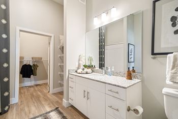a bathroom with white cabinets and a large mirror and a sink